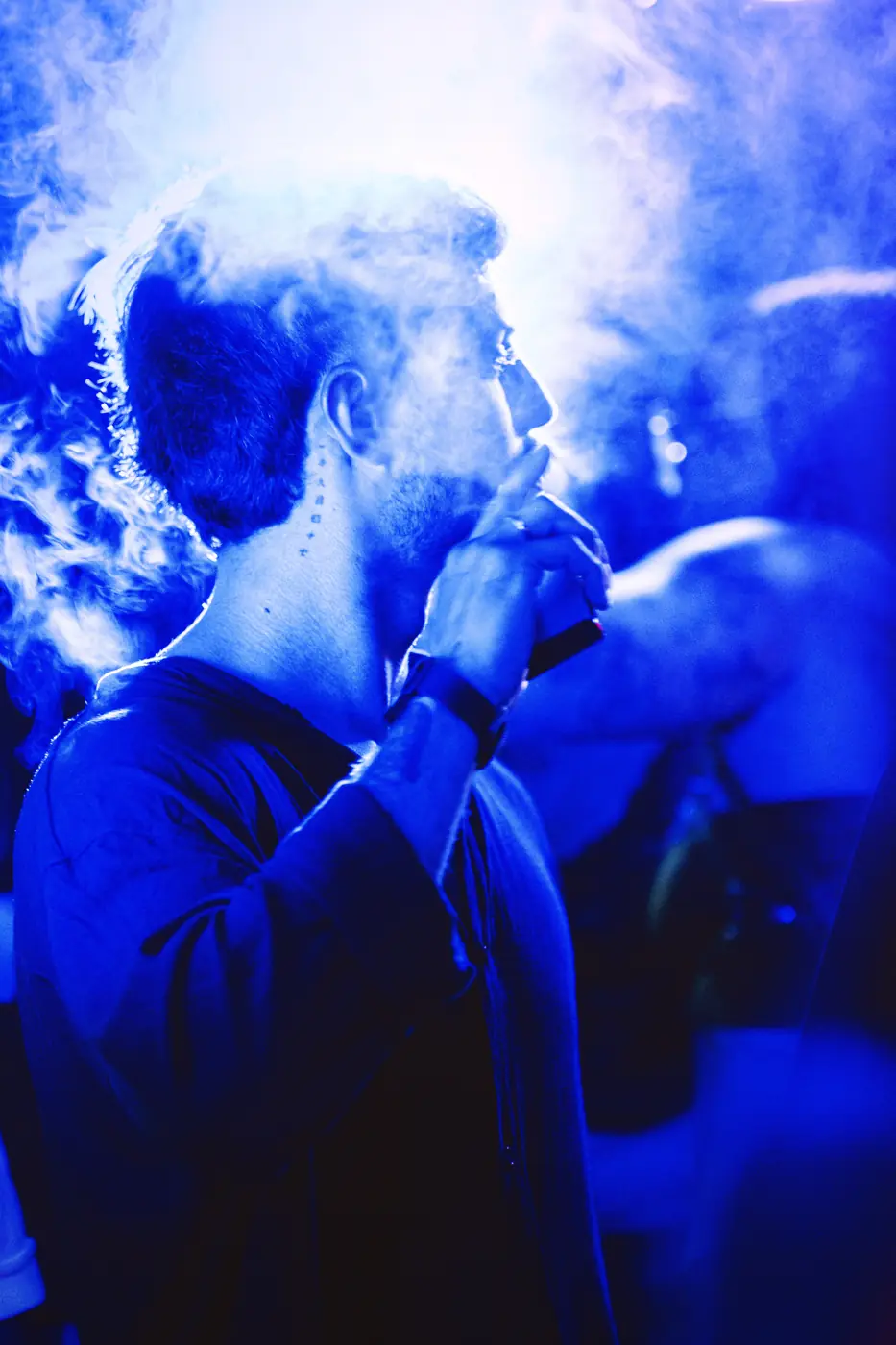 Silueta entre humo y luz azul